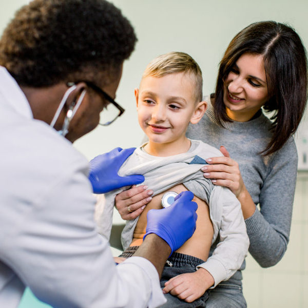 portrait of a little boy being checked by a doctor using a stethoscope